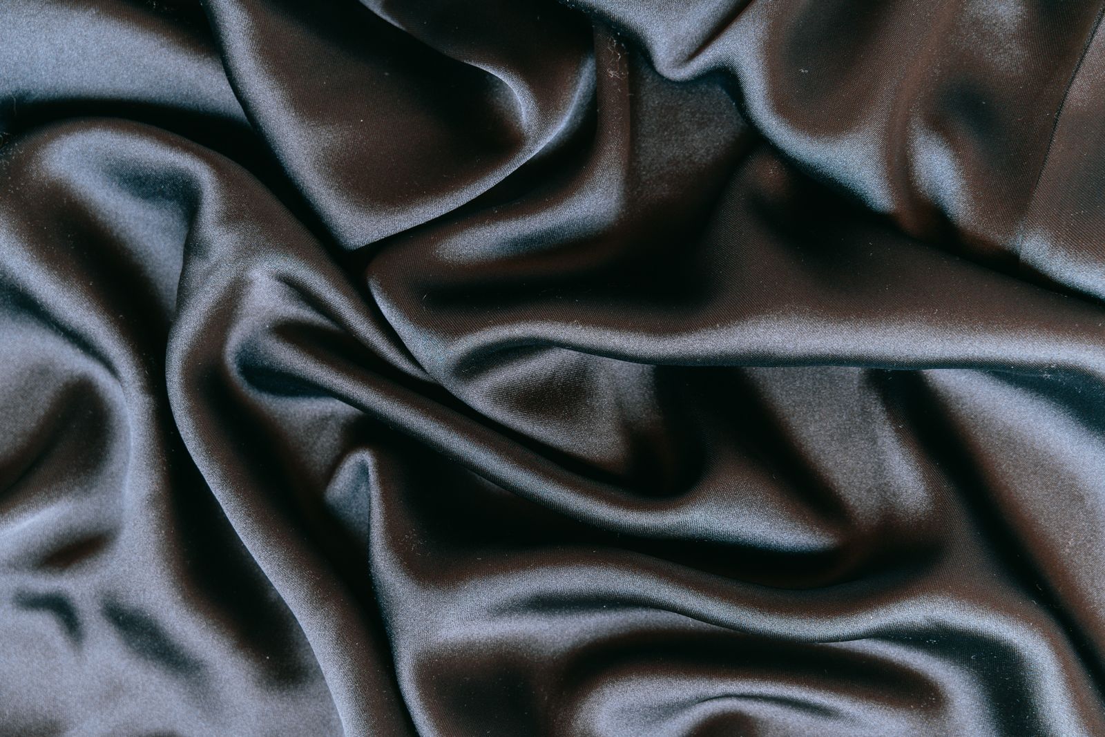 Tissu satiné gris anthracite aux plis lisses et brillants, gros plan